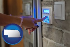 nebraska map icon and woman pressing a key on a home alarm keypad
