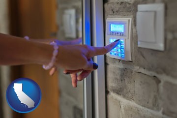 woman pressing a key on a home alarm keypad - with California icon