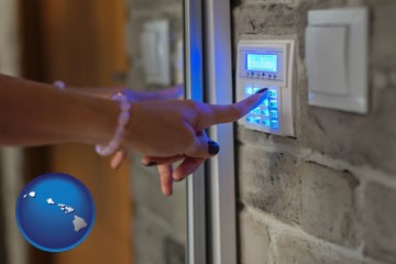 woman pressing a key on a home alarm keypad - with Hawaii icon