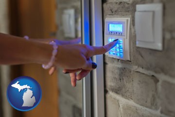 woman pressing a key on a home alarm keypad - with Michigan icon