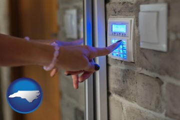 woman pressing a key on a home alarm keypad - with North Carolina icon