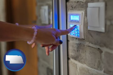 woman pressing a key on a home alarm keypad - with Nebraska icon
