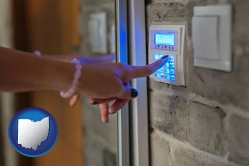 woman pressing a key on a home alarm keypad - with Ohio icon