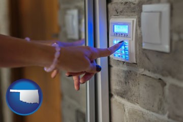woman pressing a key on a home alarm keypad - with Oklahoma icon