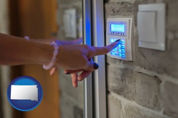 woman pressing a key on a home alarm keypad - with South Dakota icon