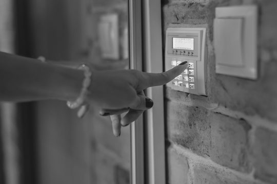 woman pressing a key on a home alarm keypad